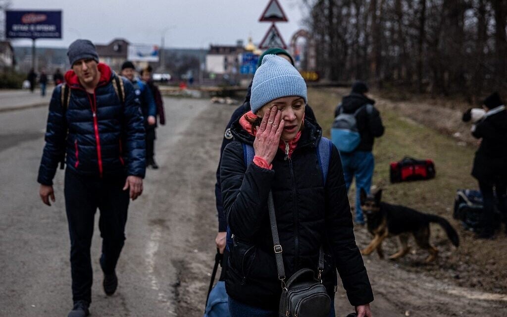 A woman cries as she flees the city of Irpin, northwest of Kyiv, on March 7, 2022 (Dimitar DILKOFF / AFP)