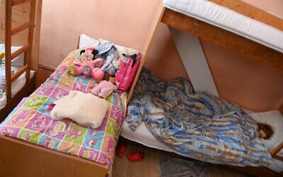 A Ukrainian child sleeps in a Hungarian-language boarding school in Berehove, western Ukraine, March 7, 2022. (ATTILA KISBENEDEK / AFP)