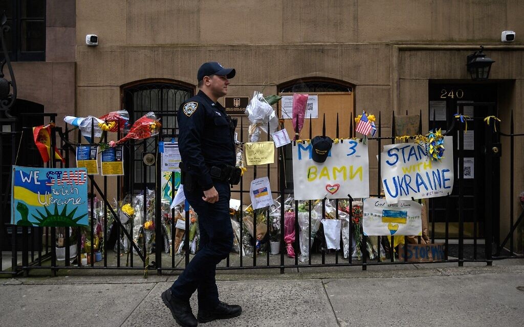 A police officer stands near messages of support displayed outside the Ukrainian consulate in New York on March 10, 2022. (Ed JONES / AFP)