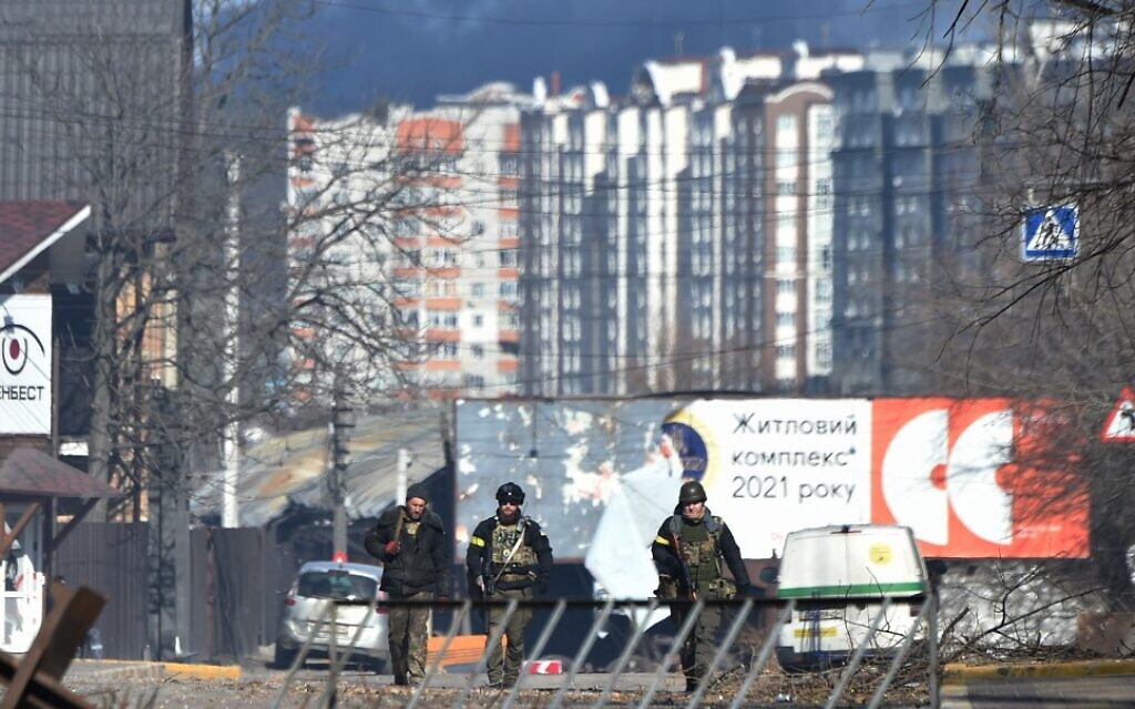 Ukrainian soldiers walk in Irpin, north of Kyiv, on March 12, 2022, as Russian forces step up pressure on Kyiv. (Sergei Supinsky/AFP)