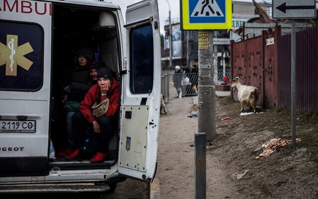 People sit in an ambulance as they flee the city of Irpin, northwest of Kyiv, on March 13, 2022 (Dimitar DILKOFF / AFP)