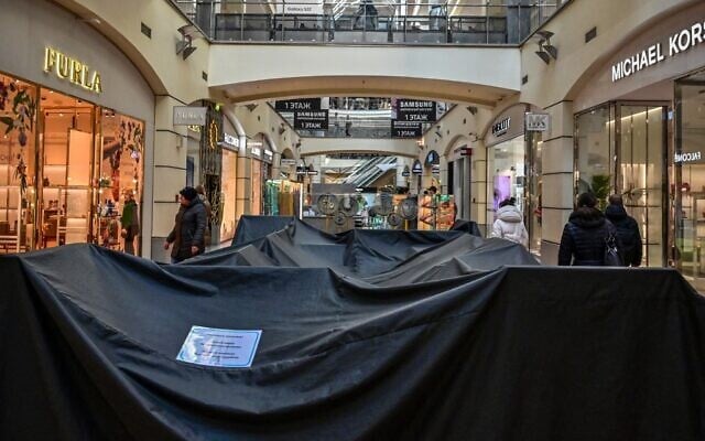 Customers walk past a closed shop counter at the Atrium shopping center in Moscow on March 17, 2022. (AFP) Customers walk past a closed shop counter at the Atrium shopping center in Moscow on March 17, 2022. (AFP)