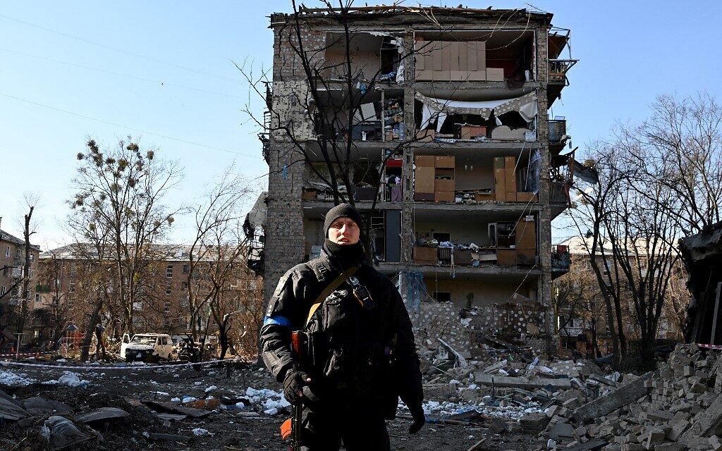 A Ukrainian policeman secures the area by a five-story residential building that partially collapsed after a shelling in Kyiv on March 18, 2022, as Russian troops try to encircle the Ukrainian capital as part of their slow-moving offensive (Sergei SUPINSKY / AFP)