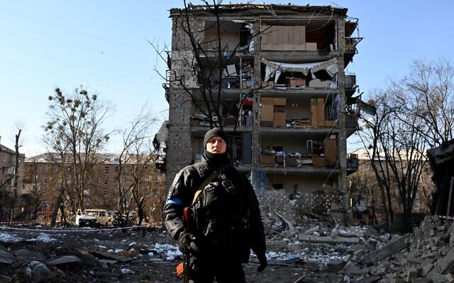 A Ukrainian policeman secures the area by a five-story residential building that partially collapsed after a shelling in Kyiv on March 18, 2022, as Russian troops try to encircle the Ukrainian capital as part of their slow-moving offensive (Sergei SUPINSKY / AFP) A Ukrainian policeman secures the area by a five-story residential building that partially collapsed after a shelling in Kyiv on March 18, 2022, as Russian troops try to encircle the Ukrainian capital as part of their slow-moving offensive (Sergei SUPINSKY / AFP)