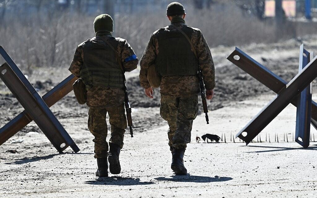 Ukrainian soldiers walk on the front line, near Kyiv, on March 20, 2022. (Genya SAVILOV / AFP)
