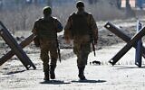 Ukrainian soldiers walk on the front line, near Kyiv, on March 20, 2022. (Genya SAVILOV / AFP)
