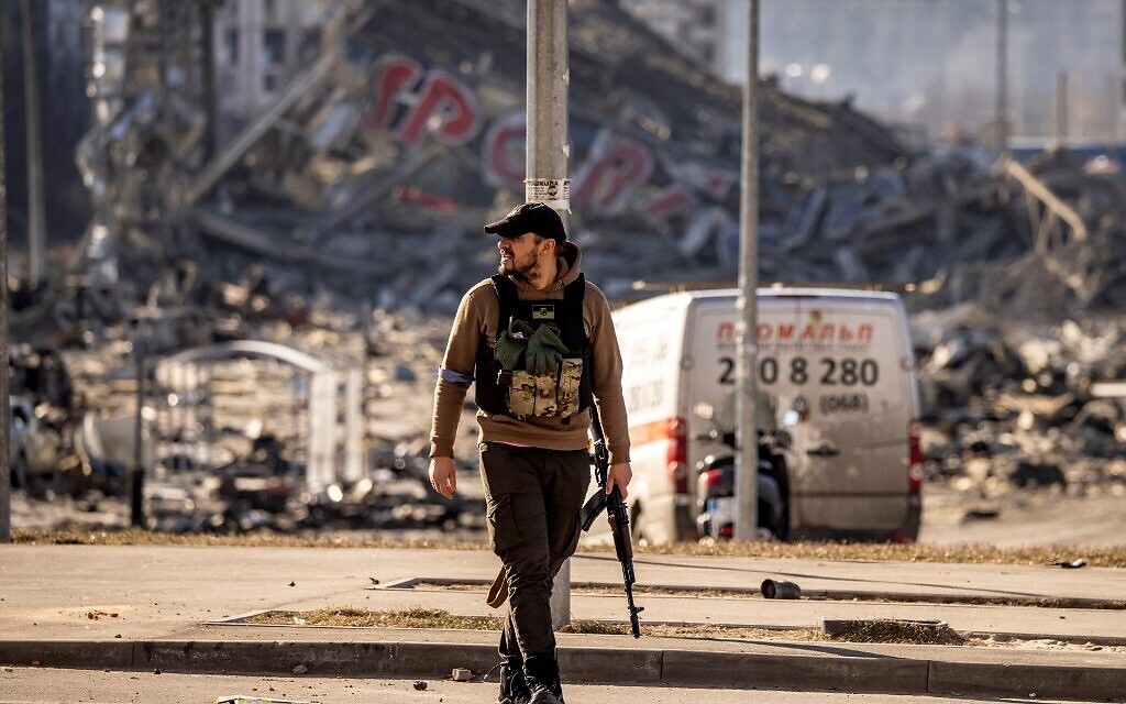 A Ukranian serviceman walks with his weapon in front of the rubble of the Retroville shopping mall, a day after it was shelled by Russian forces in a residential district in the northwest of the Ukranian capital Kyiv on March 21, 2022. (FADEL SENNA / AFP)