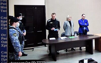 Russian opposition leader Alexei Navalny is seen on a screen via a video link during the verdict in his embezzlement and contempt of court trial at the IK-2 prison colony in the town of Pokrov in Vladimir Region on March 22, 2022. (AFP)