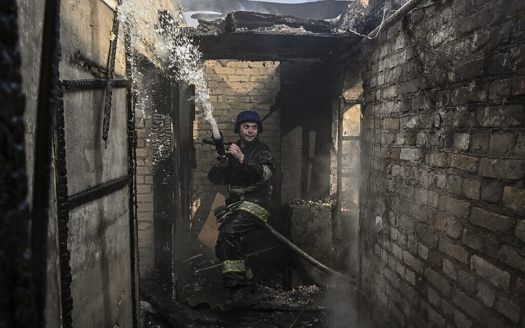 A firefighter extinguishes a burning house hit by Russian Grad rockets in Kyiv's Shevchenkivsky district, on March 23, 2023, as for the first time, there are signs that Ukrainian forces are going on the offensive, retaking a town near Kyiv and attacking Russian forces in the south of the country. (Aris Messinis / AFP)