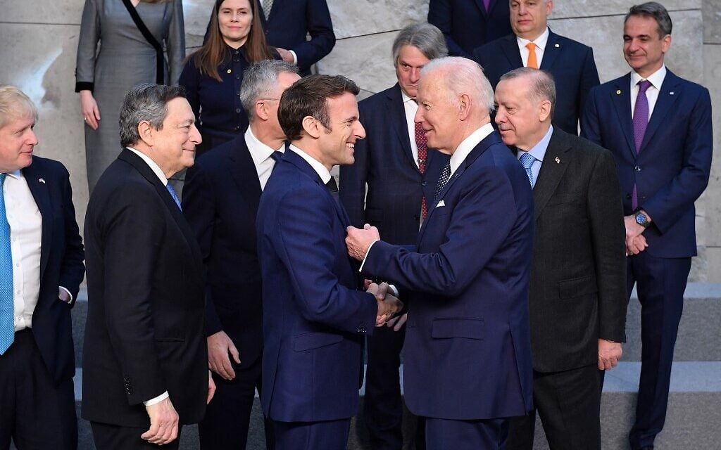 US President Joe Biden, (foreground, right) shakes hands with France's President Emmanuel Macron, next to Britain's Prime Minister Boris Johnson (back left) and Italy's Prime Minister Mario Draghi (second left in back) at NATO Headquarters in Brussels on March 24, 2022. (JOHN THYS / AFP)