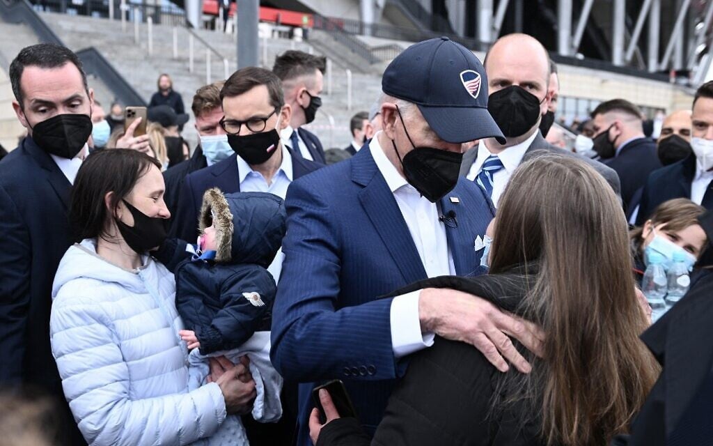US President Joe Biden (2nd R) and Polish Prime Minister Mateusz Morawiecki (C) greet Ukrainian refugees at PGE Narodowy Stadium in Warsaw, Poland, on March 26, 2022. (Brendan Smialowski/AFP)