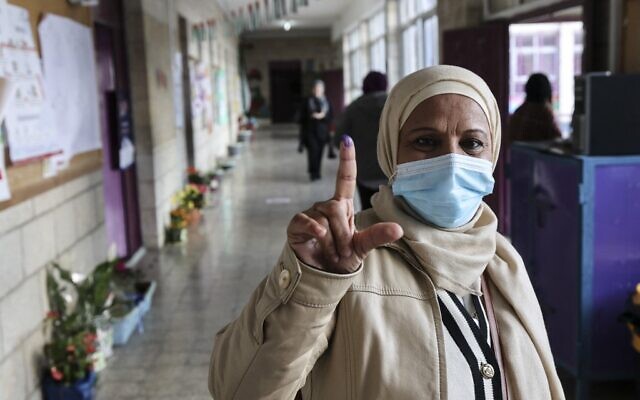 A woman shows her ink-stained finger after voting in the Palestinian local elections in the West Bank city of al-Bireh, on March 26, 2022. (Abbas Momani/AFP) A woman shows her ink-stained finger after voting in the Palestinian local elections in the West Bank city of al-Bireh, on March 26, 2022. (Abbas Momani/AFP)
