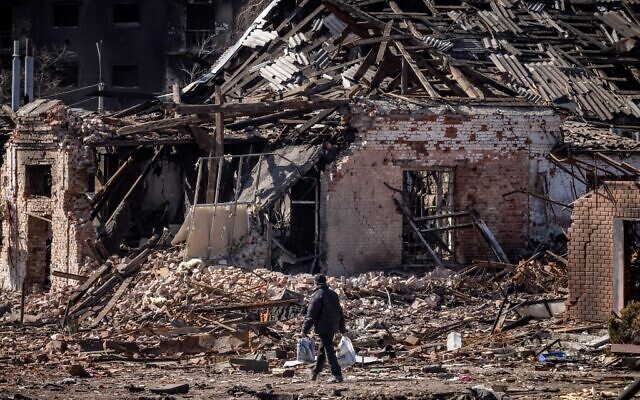 A resident walks in front of a destroyed building in the northeastern city of Trostyanets, on March 29, 2022. (FADEL SENNA / AFP) A resident walks in front of a destroyed building in the northeastern city of Trostyanets, on March 29, 2022. (FADEL SENNA / AFP)