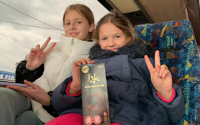 Two Ukrainian-Jewish girls shown on a bus in Moldova arranged for their families by Christians for Israel, March 7, 2022. (Courtesy of Christians for Israel/ via JTA)