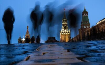 People walk through Red Square after sunset in Moscow, Russia, on March 3, 2019, with the St. Basil's, left, and the Spasskaya Tower, second right, in the background. Russian technology workers are fleeing the country by the tens of thousands as the economy goes into a tailspin under pressure from international sanctions. For some countries, Russia’s loss is being seen as their potential gain and an opportunity to bring fresh expertise to their own high-tech industries. (AP Photo/Alexander Zemlianichenko, File)