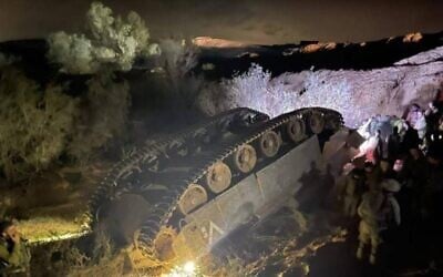 Soldiers inspect an IDF Namer APC that flipped over during an exercise in southern Israel on March 3, 2022. (Courtesy)