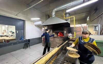 A factory worker makes shmura matzah under supervision in Ukraine. (Courtesy of Meyer Stambler/ via JTA)
