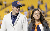 Ashton Kutcher, left, and Mila Kunis walk along the sideline before the NFL football game between the Pittsburgh Steelers and the Chicago Bears at Heinz Field on Sept. 22, 2013, in Pittsburgh. (AP Photo/Don Wright)