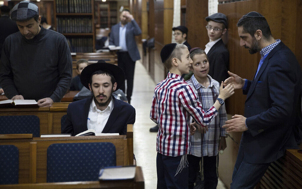 Illustrative: Children play as men pray during the International Holocaust Survivors Night of the Jewish Community at the Jewish Community Center and Synagogue in Moscow, Russia, Tuesday, December 4, 2018. (AP Photo/Pavel Golovkin)
