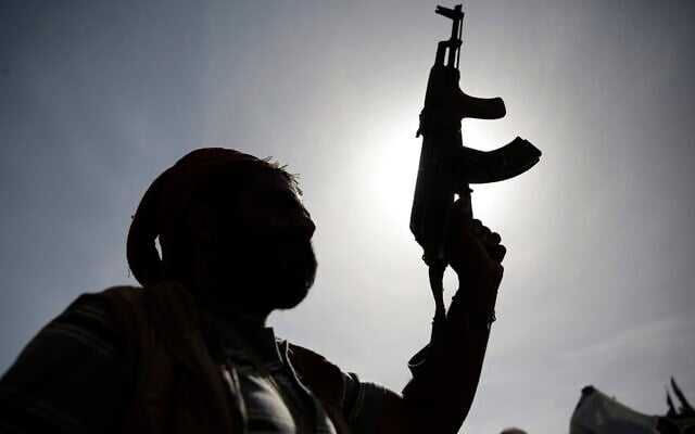 Illustrative: A silhouette of a Houthi supporter holds his weapon during a rally marking six years for a Saudi-led coalition in Sanaa, Yemen, on Friday, March 26, 2021. (AP Photo/Hani Mohammed) Illustrative: A silhouette of a Houthi supporter holds his weapon during a rally marking six years for a Saudi-led coalition in Sanaa, Yemen, on Friday, March 26, 2021. (AP Photo/Hani Mohammed)