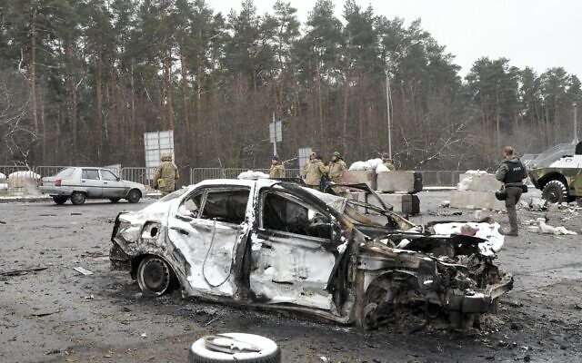Ukrainian servicemen and volunteers of Ukraine's Territorial Defense Forces stand behind a damaged car at a checkpoint in Brovary, outside Kyiv, Ukraine, March 1, 2022. (Efrem Lukatsky/AP) Ukrainian servicemen and volunteers of Ukraine's Territorial Defense Forces stand behind a damaged car at a checkpoint in Brovary, outside Kyiv, Ukraine, March 1, 2022. (Efrem Lukatsky/AP)