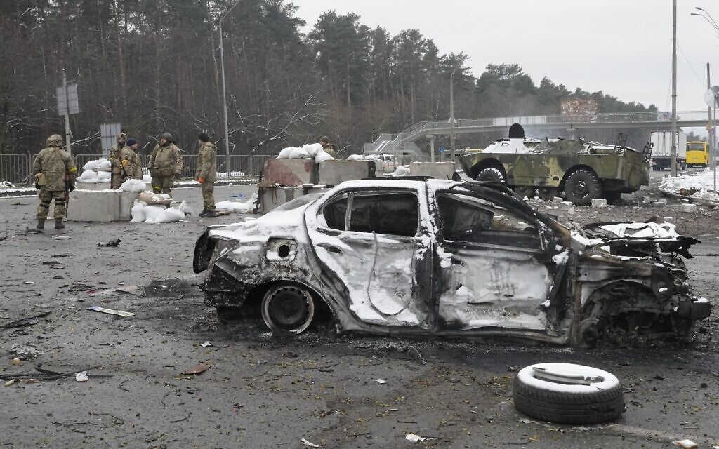 Ukrainian servicemen stand near a damaged car and an armored vehicle at a checkpoint in Brovary, outside Kyiv, Ukraine, March 1, 2022. (AP Photo/Efrem Lukatsky) Ukrainian servicemen stand near a damaged car and an armored vehicle at a checkpoint in Brovary, outside Kyiv, Ukraine, March 1, 2022. (AP Photo/Efrem Lukatsky)