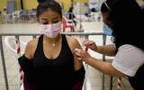 A healthcare worker administers an AstraZeneca booster shot for COVID-19 at a vaccination center in Guatemala City, March 1, 2022.  (AP Photo/Moises Castillo)