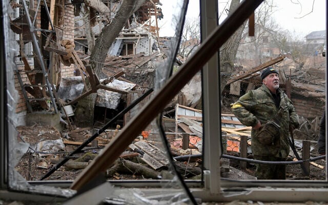 A member of the territorial defense stands in the backyard of a house damaged by a Russian airstrike, according to locals, in Gorenka, outside the capital Kyiv, Ukraine, March 2, 2022. (Vadim Ghirda/AP) A member of the territorial defense stands in the backyard of a house damaged by a Russian airstrike, according to locals, in Gorenka, outside the capital Kyiv, Ukraine, March 2, 2022. (Vadim Ghirda/AP)