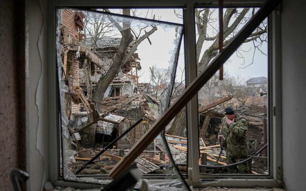 Andrey Goncharuk, 68, a member of territorial defense, wipes his face in the backyard of a house that was damaged by a Russian airstrike, according to locals, in Gorenka, outside the capital Kyiv, Ukraine, March 2, 2022. (AP Photo/Vadim Ghirda)