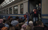 Passengers rush to board a train leaving to Slovakia from the Lviv railway station, in Lviv, west Ukraine, March 2, 2022. (Felipe Dana/AP)