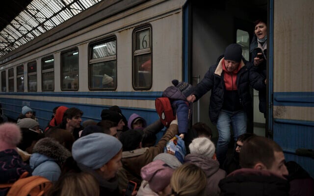 Passengers rush to board a train leaving to Slovakia from the Lviv railway station, in Lviv, west Ukraine, March 2, 2022. (Felipe Dana/AP) Passengers rush to board a train leaving to Slovakia from the Lviv railway station, in Lviv, west Ukraine, March 2, 2022. (Felipe Dana/AP)