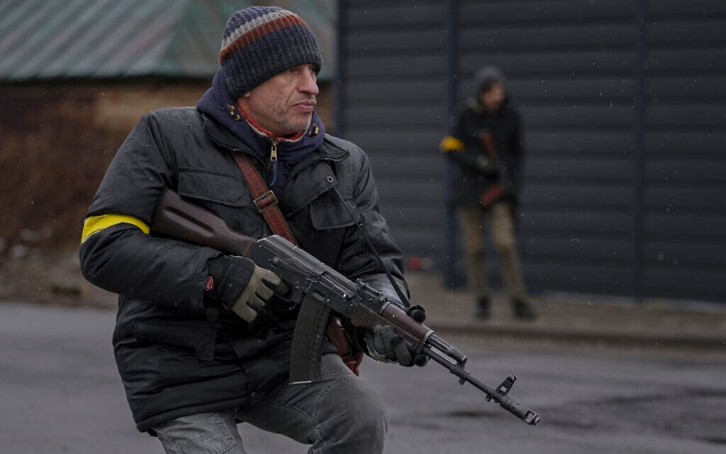 Members of the civil defense take positions as a vehicle approaches the checkpoint in Gorenka, outside the capital Kyiv, Ukraine, Wednesday, March 2, 2022. (AP/Vadim Ghirda)