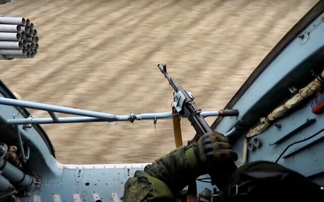 In this photo taken from video released by the Russian Defense Ministry Press Service on March 3, 2022, a Russian soldier points a gun from a Russian military helicopter as it flies over an undisclosed location in Ukraine. (Russian Defense Ministry Press Service via AP) In this photo taken from video released by the Russian Defense Ministry Press Service on March 3, 2022, a Russian soldier points a gun from a Russian military helicopter as it flies over an undisclosed location in Ukraine. (Russian Defense Ministry Press Service via AP)