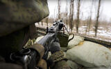 A Russian soldier points a gun from a Russian military truck as it drives through an undisclosed location in Ukraine, on March 3, 2022. (Russian Defense Ministry Press Service via AP)