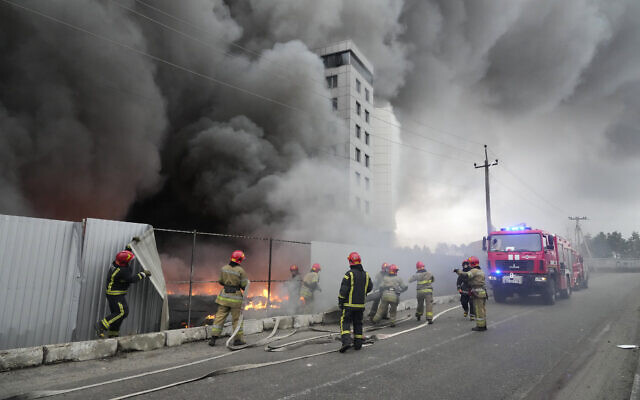 Firefighters work to extinguish a fire at a damaged logistic center after shelling in Kyiv, Ukraine, on March 3, 2022. (AP Photo/Efrem Lukatsky)