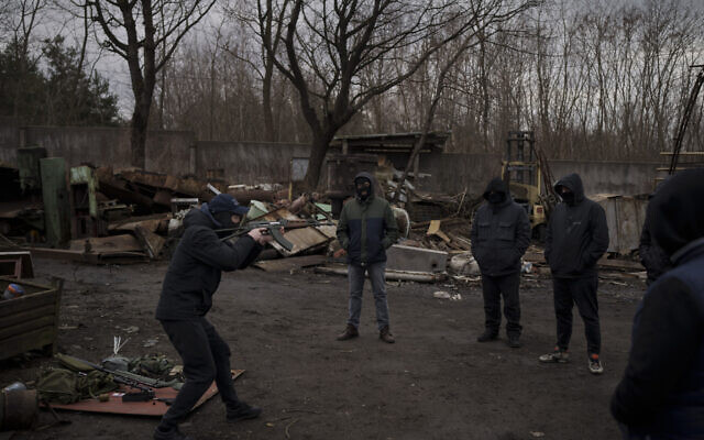 Roman, a former Ukrainian soldier injured in combat, gives instructions on how to handle weapons and move during conflict to civilians in the outskirts of Lviv, west Ukraine, March 3, 2022 (AP Photo/Felipe Dana)