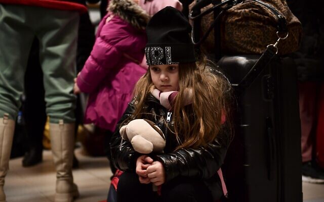 A child fleeing form Ukraine waits with her family at a railway station in Zahony, Hungary, March 4, 2022 (AP Photo/Anna Szilagyi)