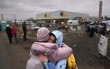 A woman weeps after finding a friend, who also fled Ukraine, at the border crossing in Medyka, Poland, Saturday, March 5, 2022 (AP Photo/Markus Schreiber)