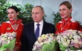 Russian President Vladimir Putin, center poses for a photo during his meeting with representatives of the flight crew of Russian airlines as he visits to Aeroflot Aviation School outside Moscow, Russia, Saturday, March 5, 2022. (Sputnik, Kremlin Pool Photo via AP)