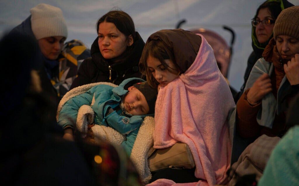 Refugees, mostly women with children, rest inside a tent after arriving at the border crossing, in Medyka, Poland on March 6, 2022. (AP Photo/Visar Kryeziu)