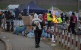 Refugees, mostly women with children, arrive at the border crossing in Medyka, Poland on March 6, 2022. (AP Photo/Visar Kryeziu)