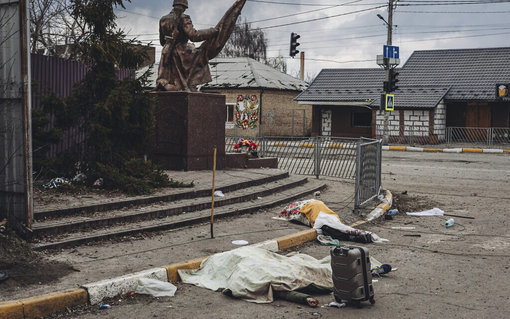 The dead bodies of people killed by Russian shelling lay covered in the street in the town of Irpin, Ukraine, March 6, 2022. (AP Photo/Diego Herrera Carcedo)