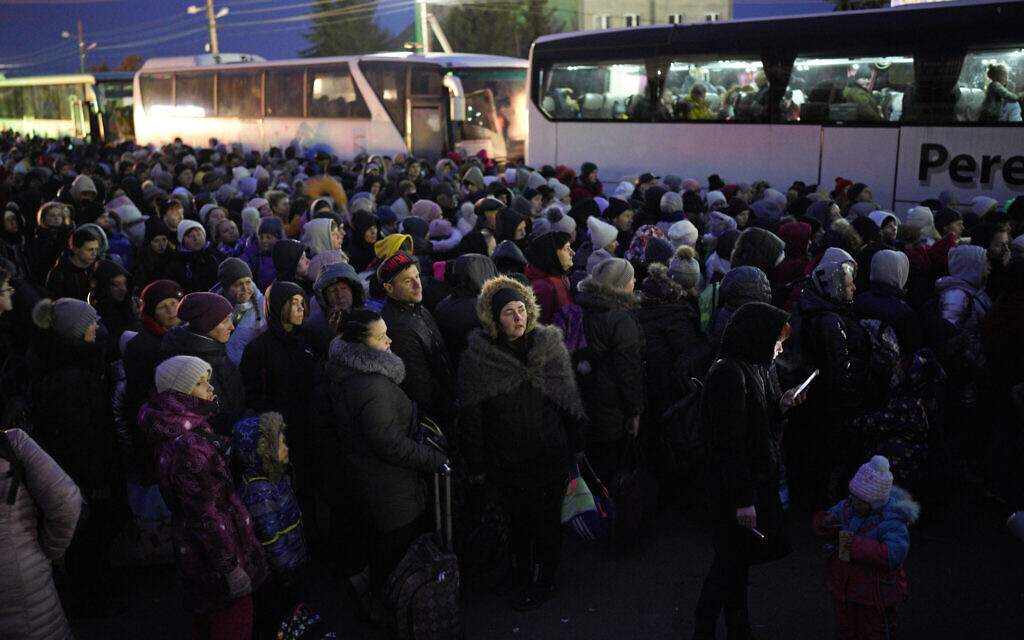 Refugees fleeing the war in Ukraine, form a line as they approach the border with Poland in Shehyni, Ukraine, March 6, 2022. (AP Photo/Daniel Cole)
