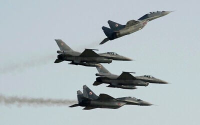 Two Polish Air Force Russian-made Mig-29s fly above and below two Polish Air Force US-made F-16 fighter jets during an air show in Radom, Poland, August 27, 2011. (AP Photo/Alik Keplicz, File)