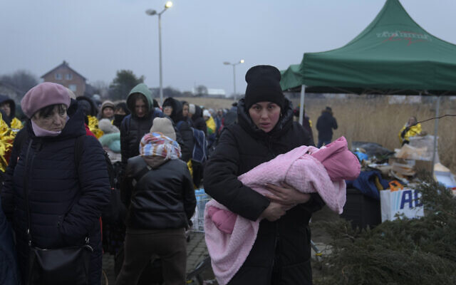 A woman with a child arrives at the border crossing after fleeing from the Ukraine in Medyka, Poland, March 7, 2022 (AP Photo/Markus Schreiber)