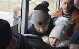 Refugees fleeing fleeing the military operation zone from the Mariupol area of Ukraine sit in a bus as they arrive at the border crossing in Veselo-Voznesenka, Russia, March 7, 2022. (AP Photo)