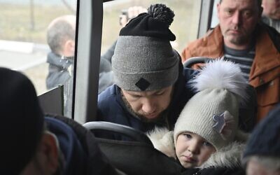 Refugees fleeing fleeing the military operation zone from the Mariupol area of Ukraine sit in a bus as they arrive at the border crossing in Veselo-Voznesenka, Russia, March 7, 2022. (AP Photo)