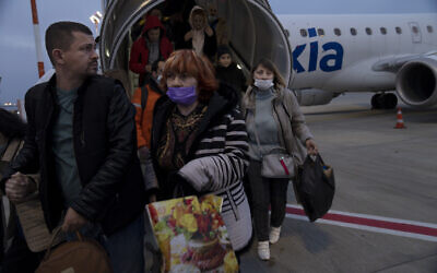Ukrainians disembark from a special flight to Israel from Romania upon landing at Ben Gurion Airport, March 8, 2022. (Maya Alleruzzo/AP)