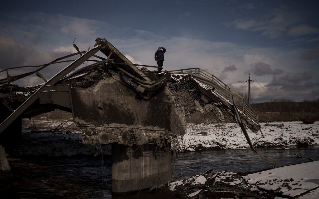 A man stands atop a destroyed bridge in Irpin, on the outskirts of Kyiv, Ukraine,  March 8, 2022. (AP Photo/Felipe Dana)