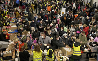 Ukrainian refugees queue for food in the welcome area after their arrival at the main train station in Berlin, Germany, March 8, 2022. (AP Photo/Michael Sohn)